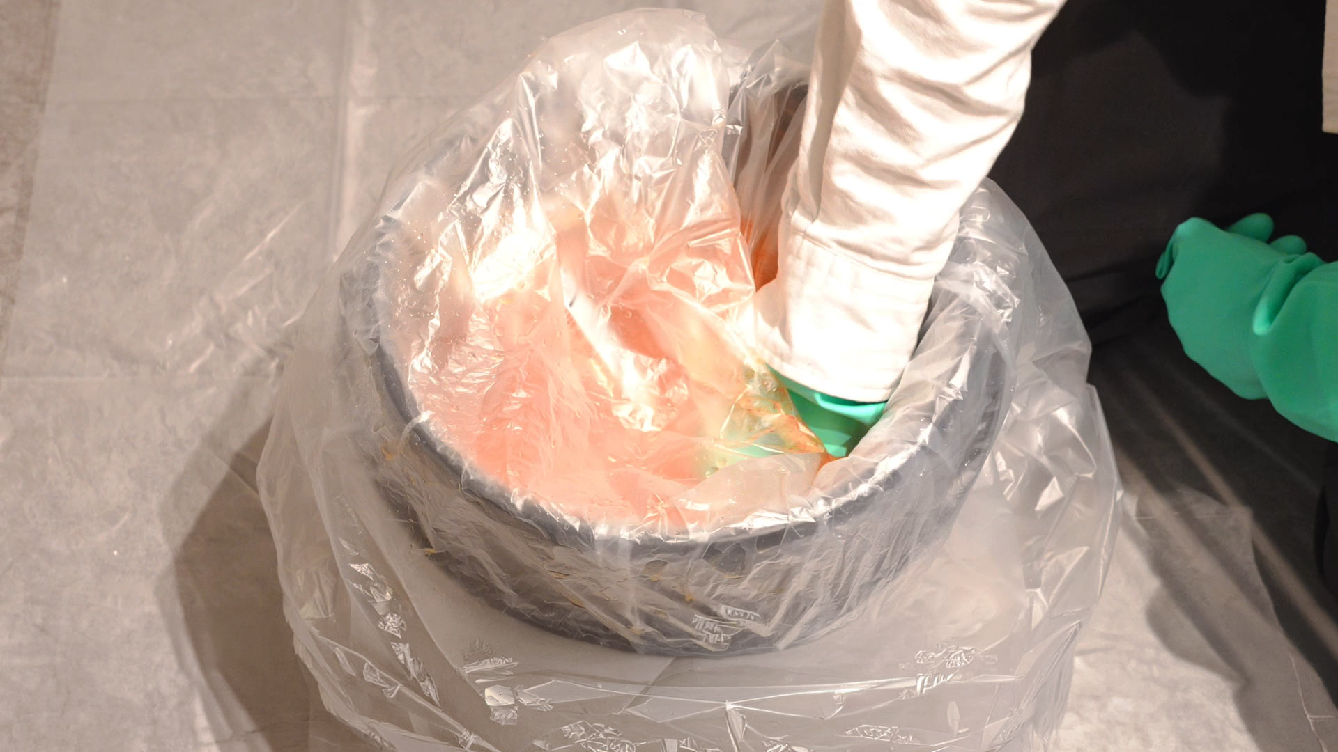 熊スプレー廃棄手順・内容物の排出。水中で噴射レバーを押し、スプレーを完全に空にする様子。