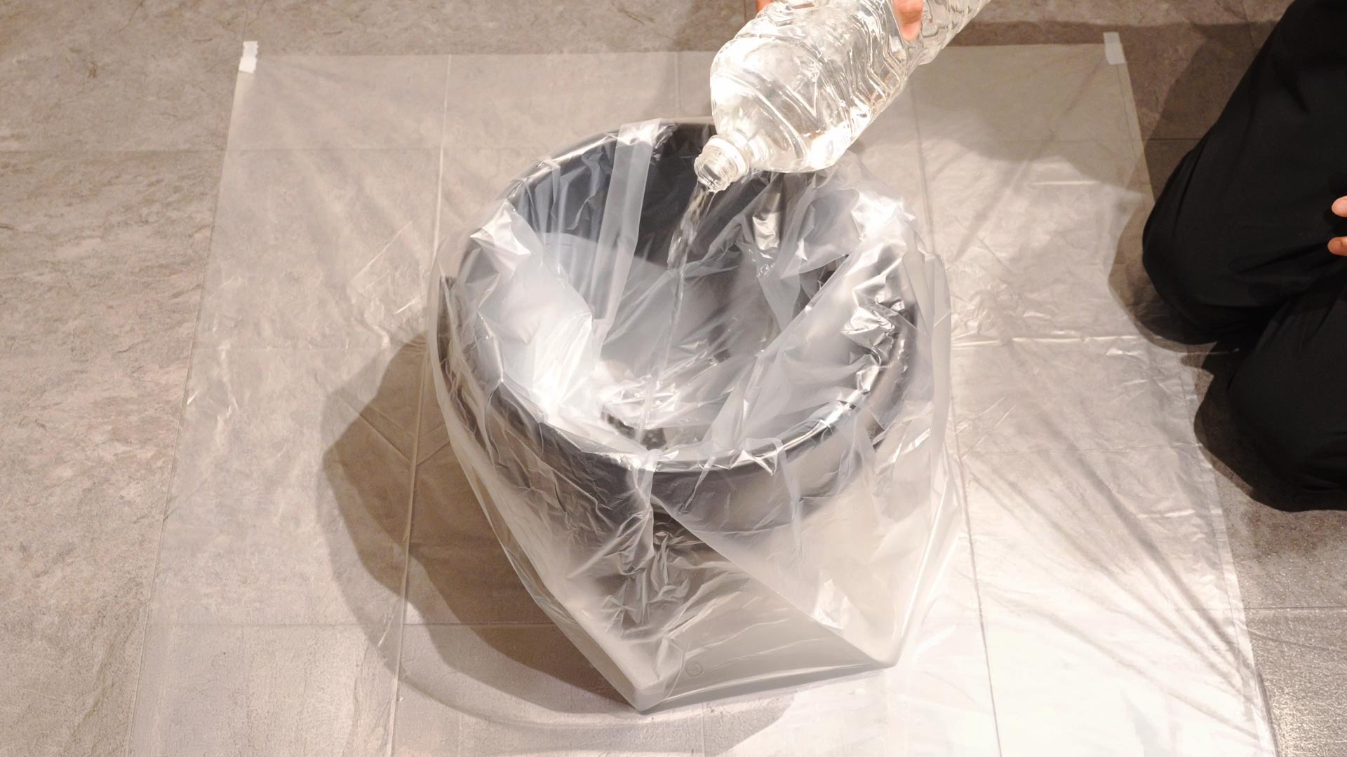 熊スプレー廃棄処理の周辺保護準備。バケツの下にポリ袋を敷き、水約5Lをセットした状態。